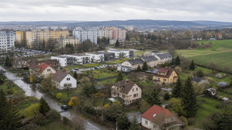 Bytový dům, panelové sídliště a rodinné domy v jedné ulici, ilustrační foto k přehledu druhů bydlení a forem vlastnictví v Česku